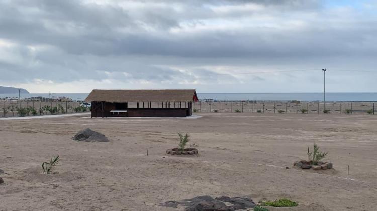 Explanada del camping con estructura cubierta y mar al fondo